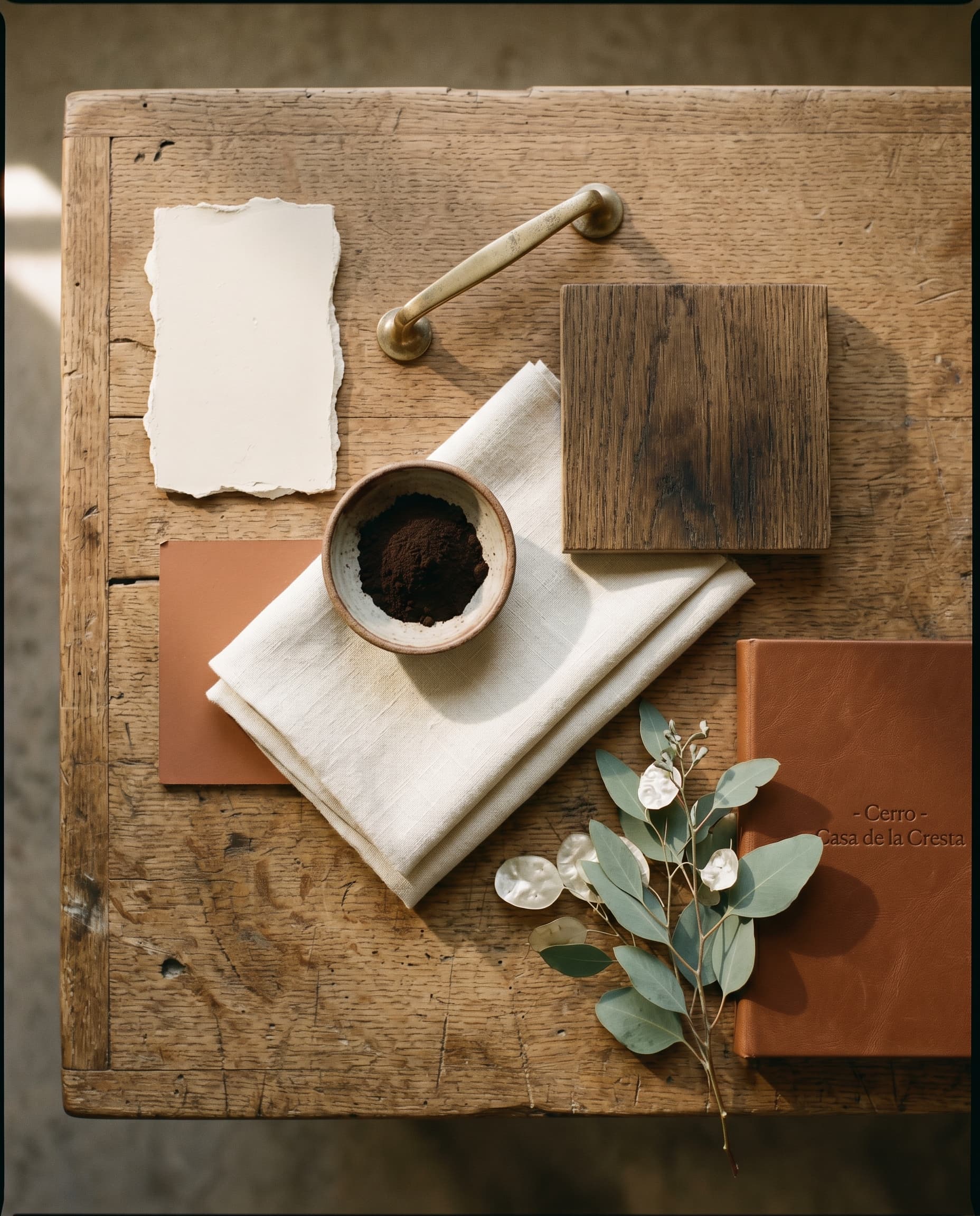 Cerro Studio materials flatlay — plaster, oak, brass, linen, eucalyptus